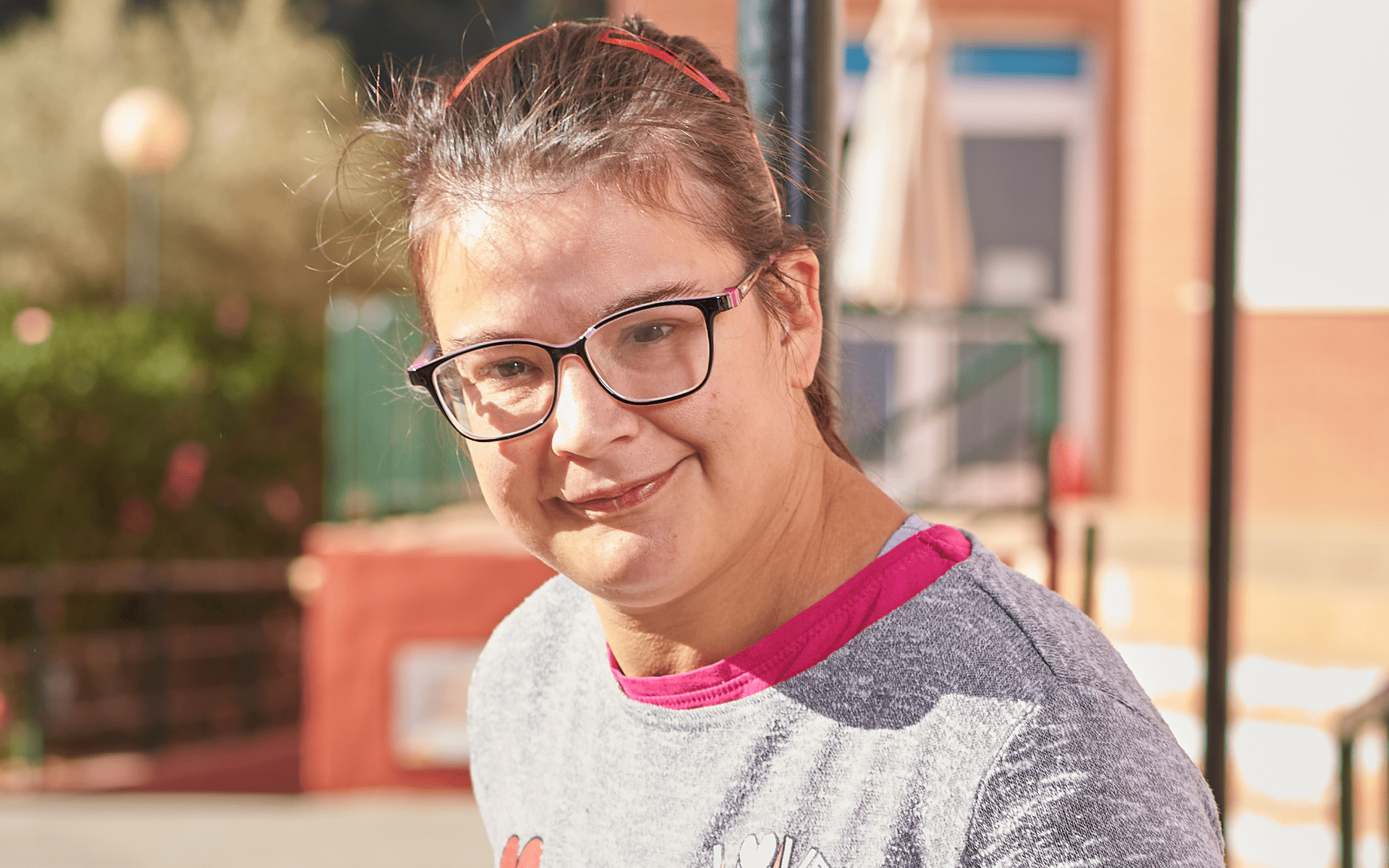 Una chica con autismo mira sonriente a la cámara.